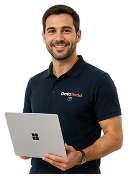 Smiling man in a navy polo shirt holding a silver laptop with a Windows logo.